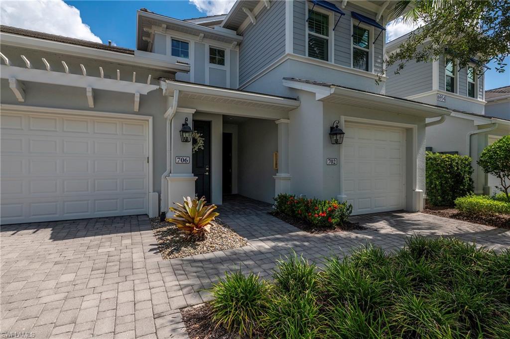 6954 Avalon Circle, Unit 702 Naples, FL 34112 - Photo 23 of 40 a view of a building with potted plants and a bench