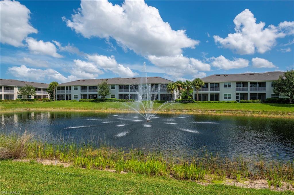 6954 Avalon Circle, Unit 702 Naples, FL 34112 - Photo 24 of 40 a view of a swimming pool and a lake in the back