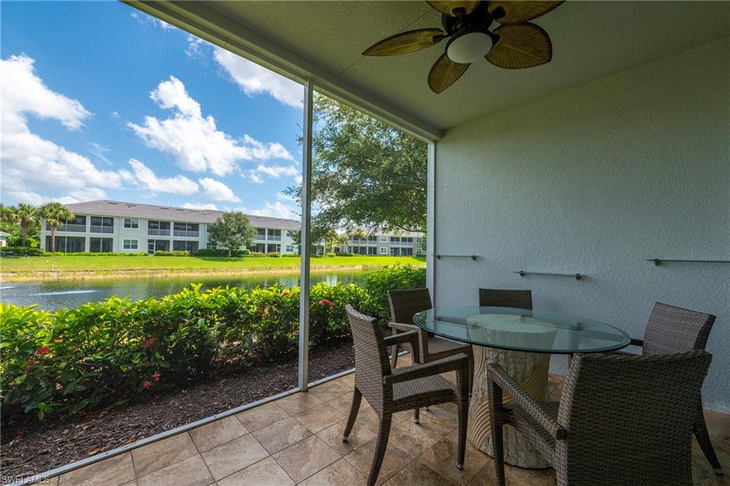 6954 Avalon Circle, Unit 702 Naples, FL 34112 - Photo 25 of 40 a view of a chairs and table in patio with a lake view