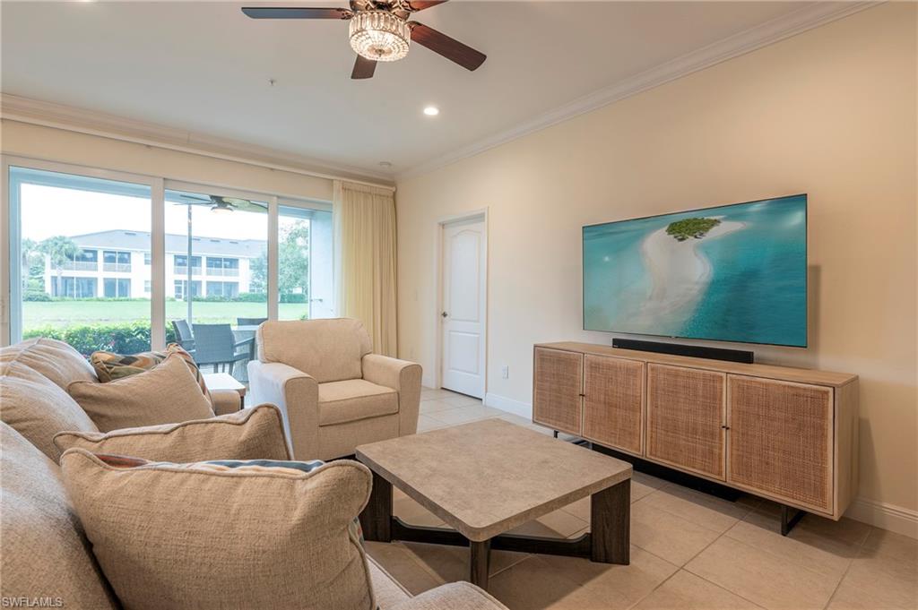 6954 Avalon Circle, Unit 702 Naples, FL 34112 - Photo 5 of 40 a living room with furniture and a flat screen tv