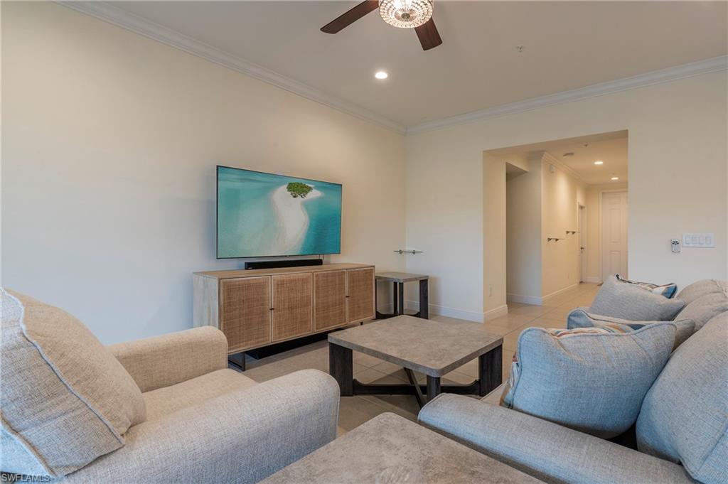 6954 Avalon Circle, Unit 702 Naples, FL 34112 - Photo 6 of 40 a living room with furniture and a flat screen tv