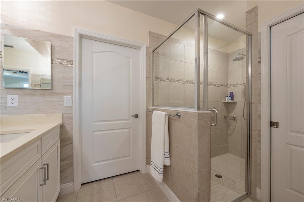 6954 Avalon Circle, Unit 702 Naples, FL 34112 - Photo 8 of 40 a bathroom with a shower and a sink