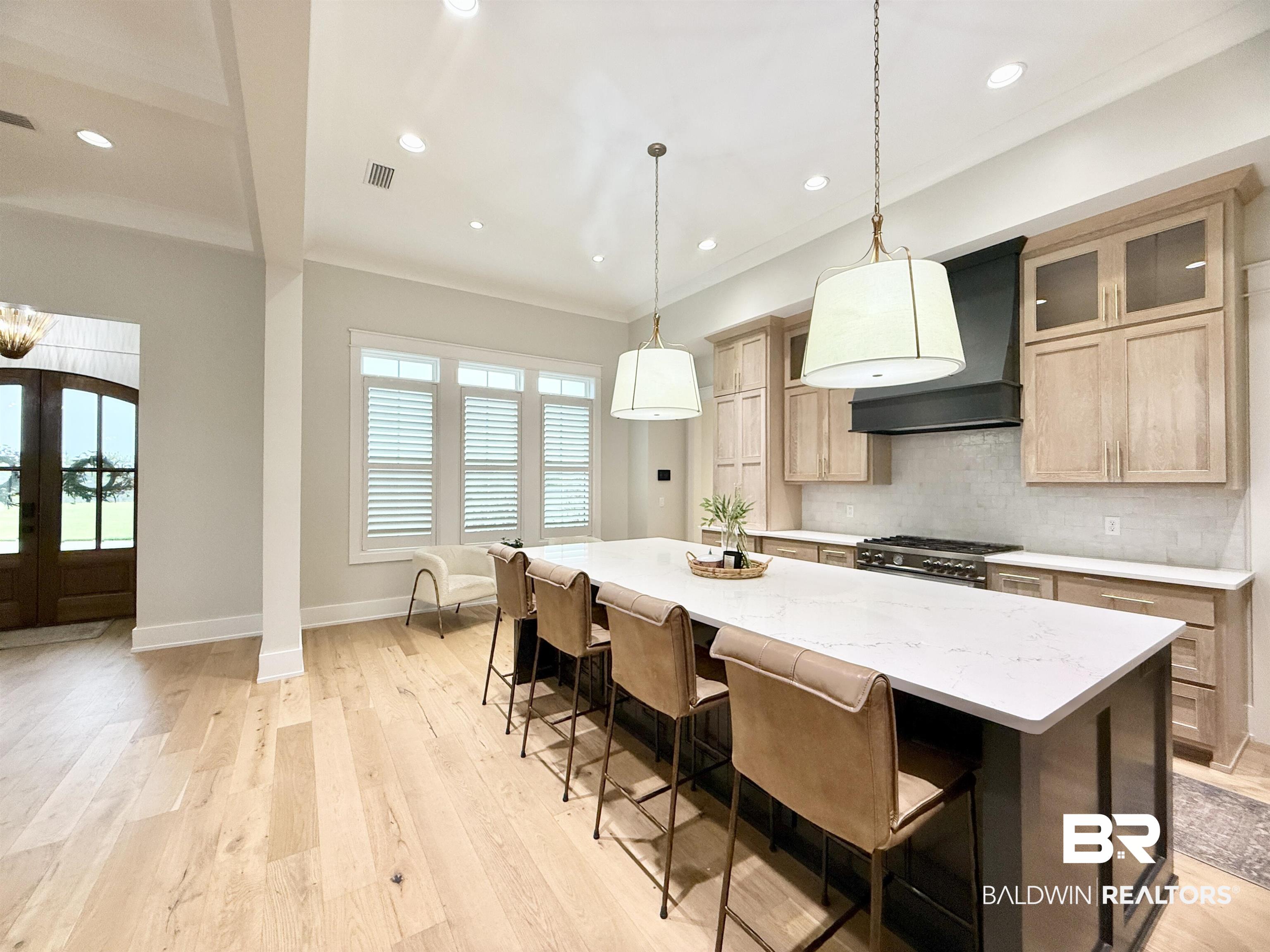 21767 Gallery Boulevard Fairhope, AL 36532 - Photo 18 of 74 Kitchen featuring custom exhaust hood, recessed lighting, backsplash, light wood-style flooring, and a center island