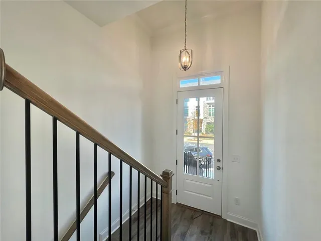 a view of a hallway with wooden floor and staircase