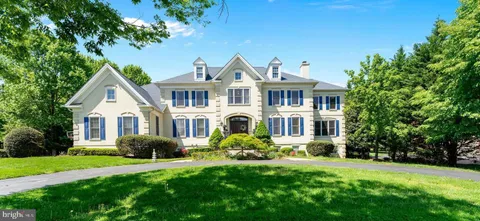 a front view of a house with a garden and trees
