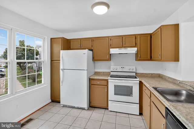 a kitchen with a stove a refrigerator and a sink