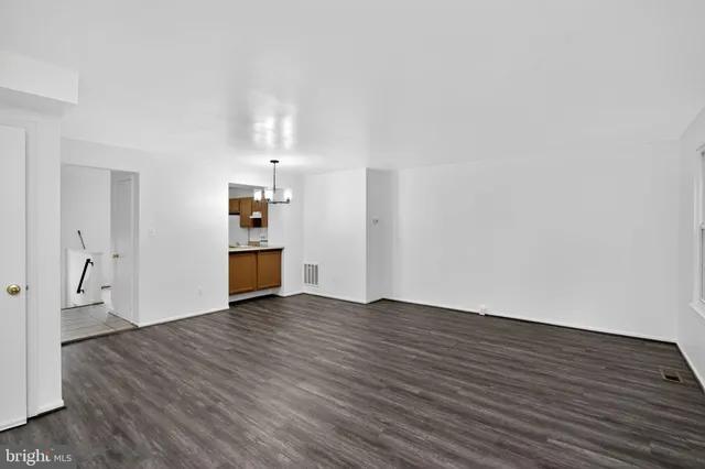 a view of a livingroom with wooden floor and a ceiling fan
