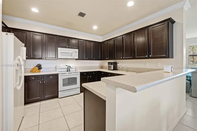 a kitchen with a sink a stove a refrigerator and cabinets