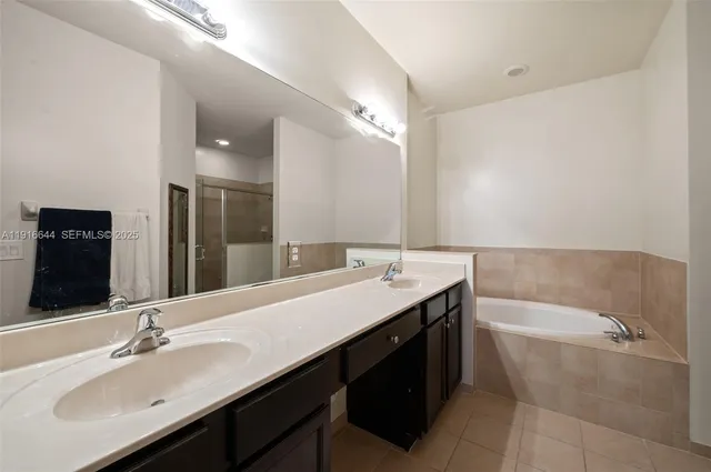 a bathroom with a tub double sink and mirror
