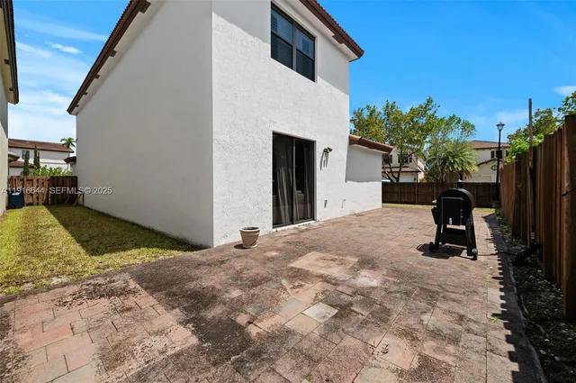 a view of a house with backyard and trees