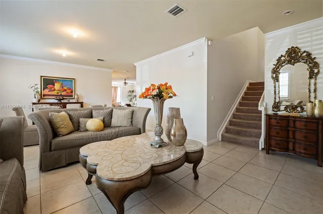 a living room with furniture a stairs and a painting