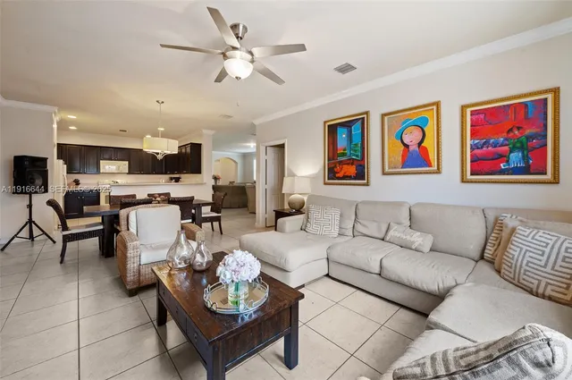 a living room with furniture kitchen view and a chandelier