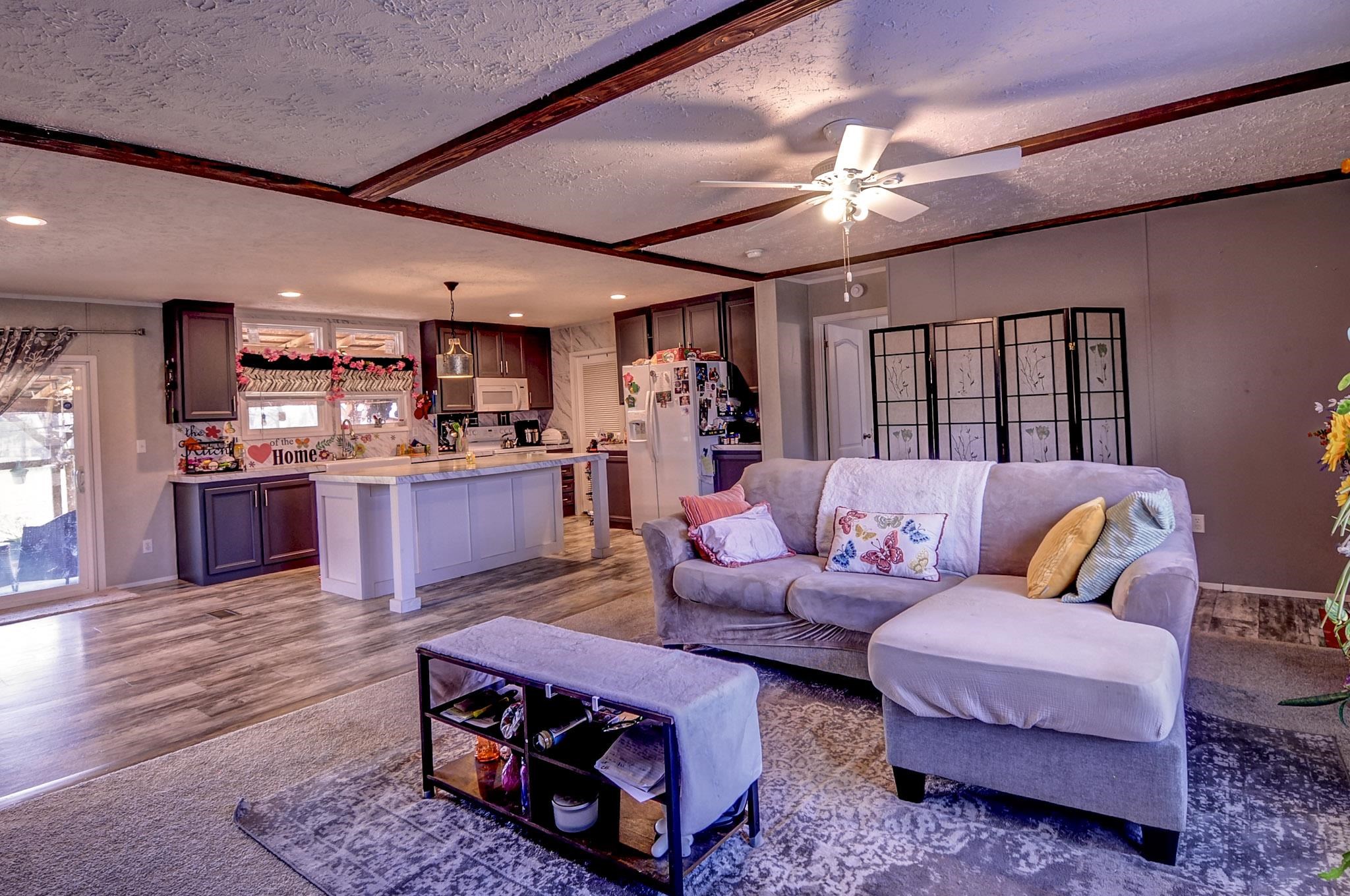 2450 South Neely Road Middleton, TN 38052 - Photo 17 of 38 Living room featuring a textured ceiling, wood finished floors, a ceiling fan, and beamed ceiling