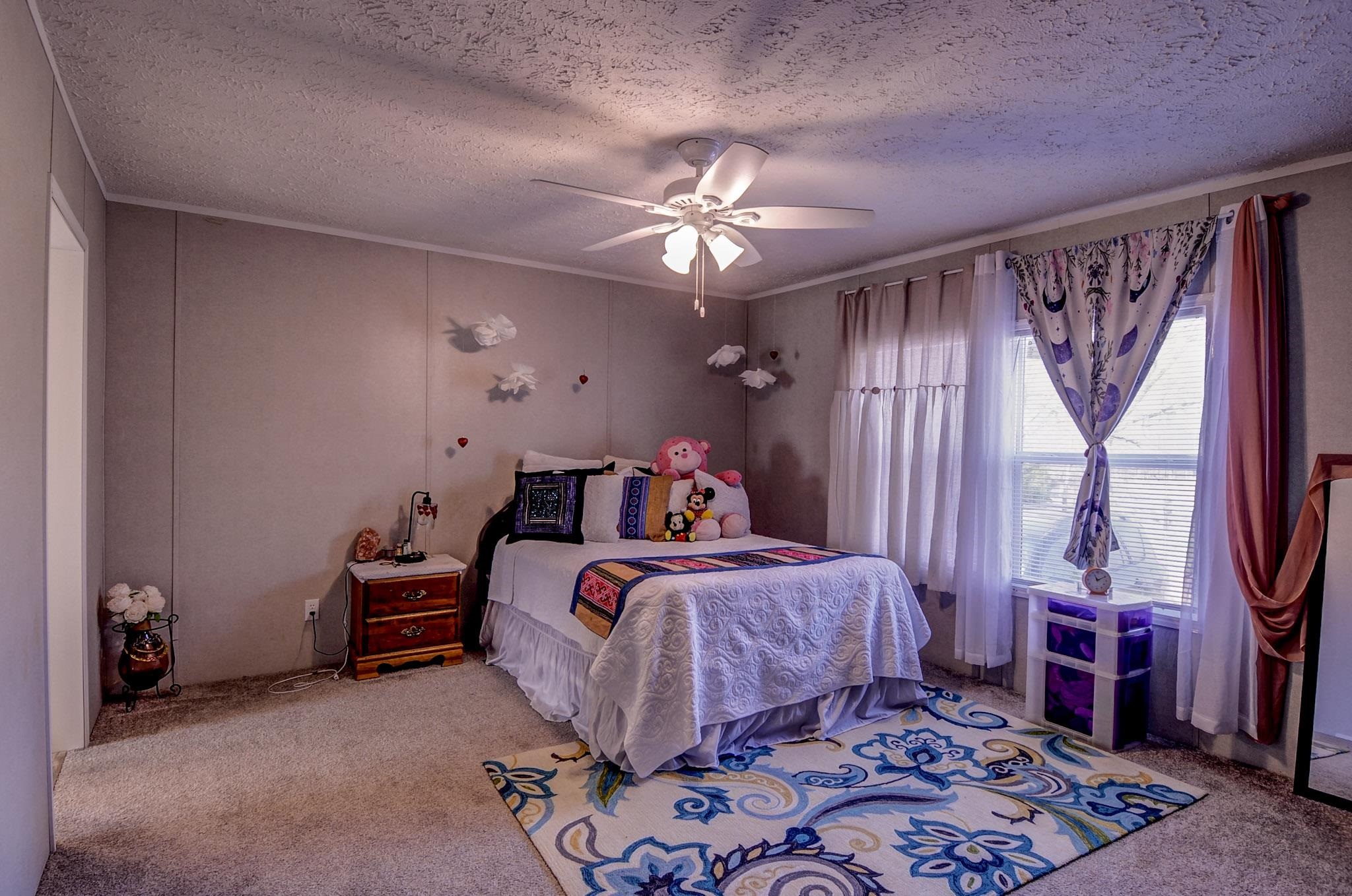 2450 South Neely Road Middleton, TN 38052 - Photo 18 of 38 Bedroom with light carpet, a textured ceiling, and a ceiling fan