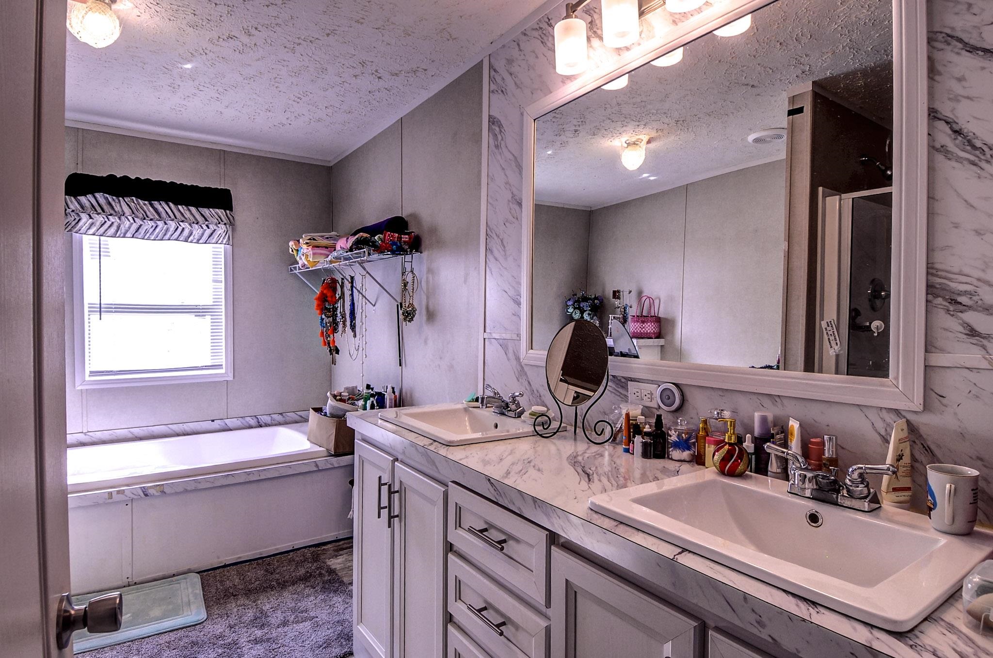 2450 South Neely Road Middleton, TN 38052 - Photo 20 of 38 Full bathroom featuring a textured ceiling, double vanity, a shower stall, and a garden tub
