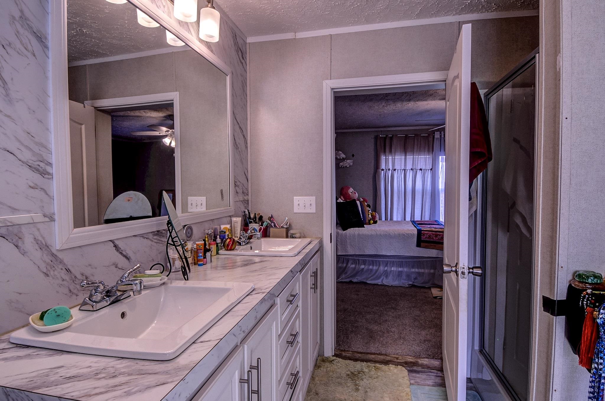 2450 South Neely Road Middleton, TN 38052 - Photo 21 of 38 Ensuite bathroom with a textured ceiling, double vanity, and a stall shower