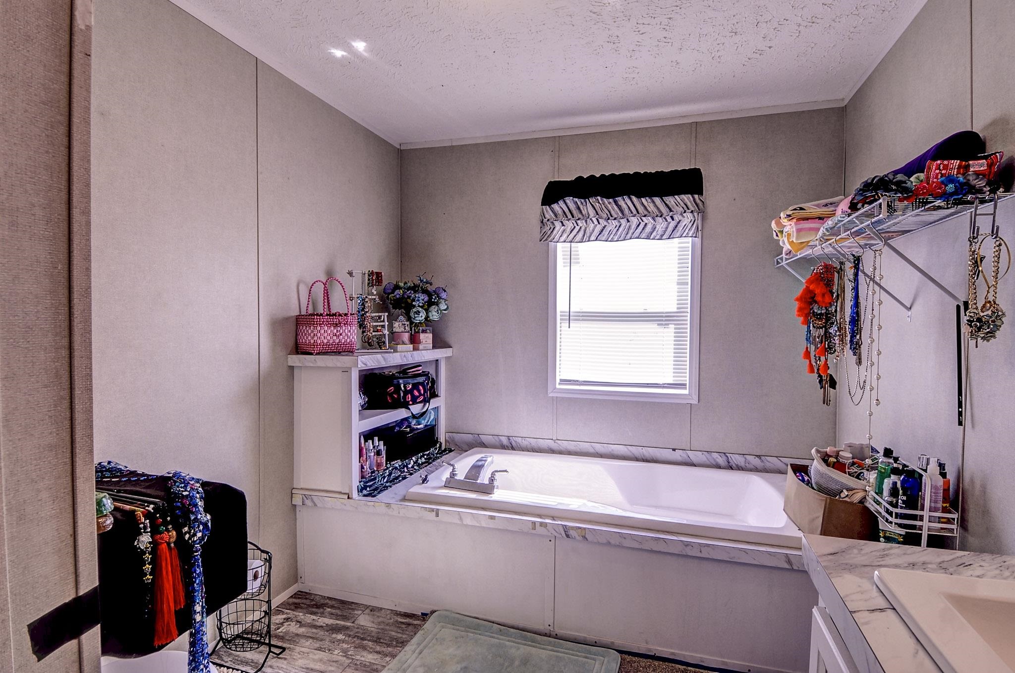 2450 South Neely Road Middleton, TN 38052 - Photo 22 of 38 Bathroom with a garden tub, vanity, a textured ceiling, and light wood finished floors