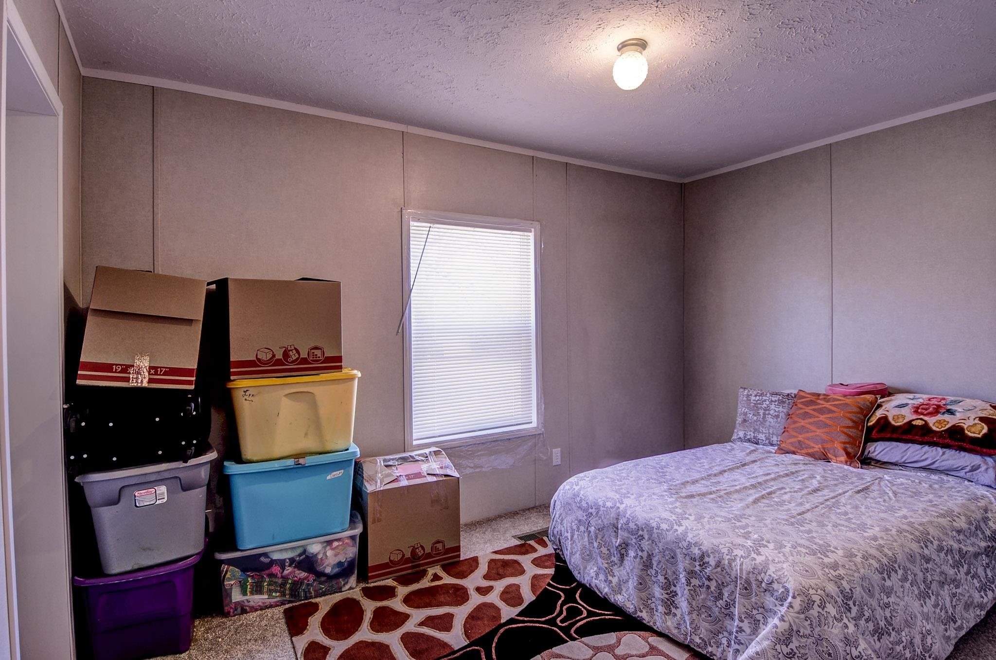 2450 South Neely Road Middleton, TN 38052 - Photo 23 of 38 Bedroom with a textured ceiling, carpet floors, a decorative wall, and crown molding
