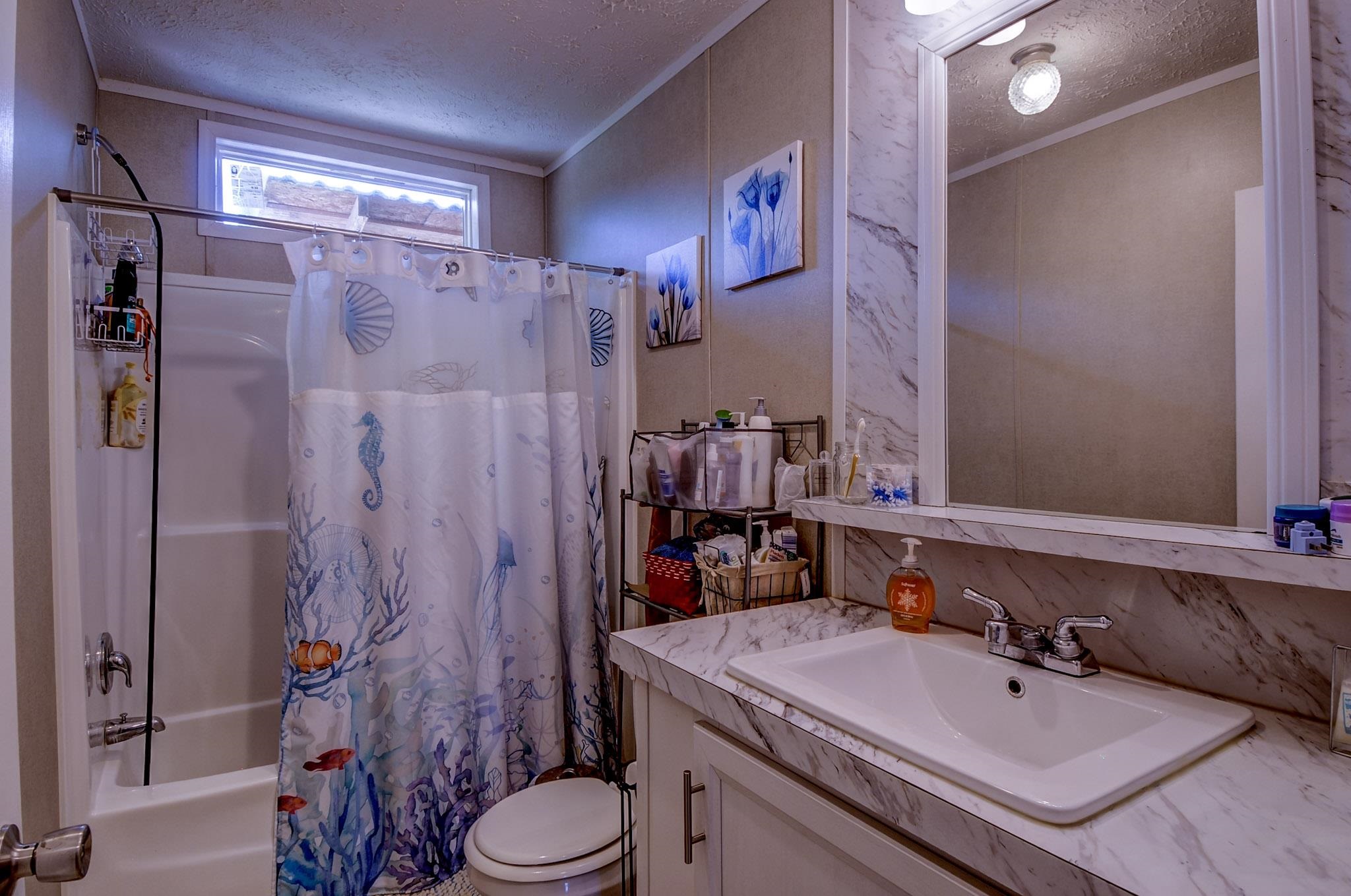 2450 South Neely Road Middleton, TN 38052 - Photo 27 of 38 Full bathroom with a textured ceiling, vanity, shower / tub combo with curtain, and ornamental molding