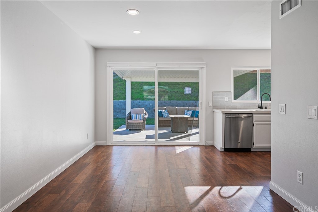 4435 Springtime Drive Oceanside, CA 92056 - Photo 10 of 52 an empty room with a fireplace and wooden floor