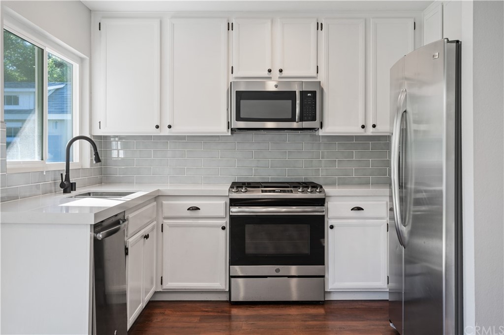 4435 Springtime Drive Oceanside, CA 92056 - Photo 14 of 52 a kitchen with stainless steel appliances white cabinets a sink and a stove