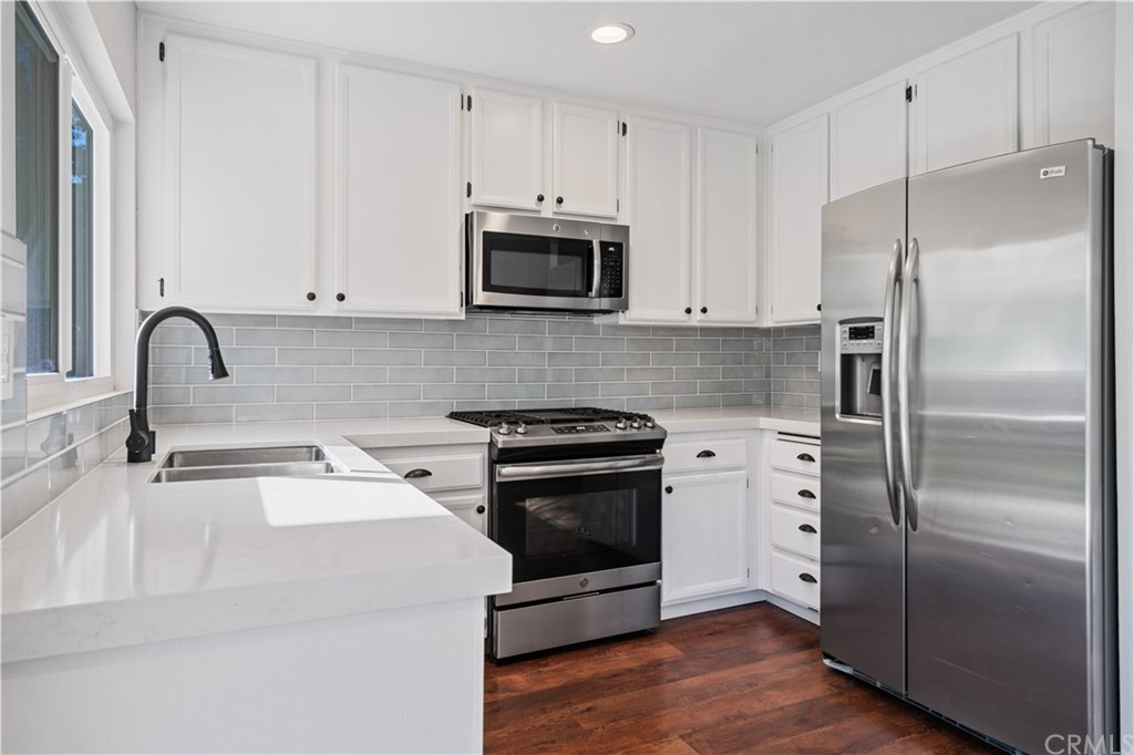4435 Springtime Drive Oceanside, CA 92056 - Photo 15 of 52 a kitchen with a refrigerator stove and white cabinets
