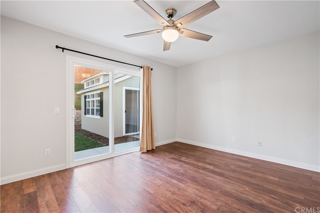 4435 Springtime Drive Oceanside, CA 92056 - Photo 21 of 52 an empty room with wooden floor fan and windows