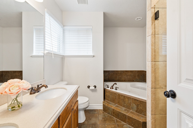 2029 West Crescent Row Mapleton, UT 84664 - Photo 15 of 28 Double vanity with integrated sinks, oil-rubbed bronze fixtures, and wood-finish cabinetry