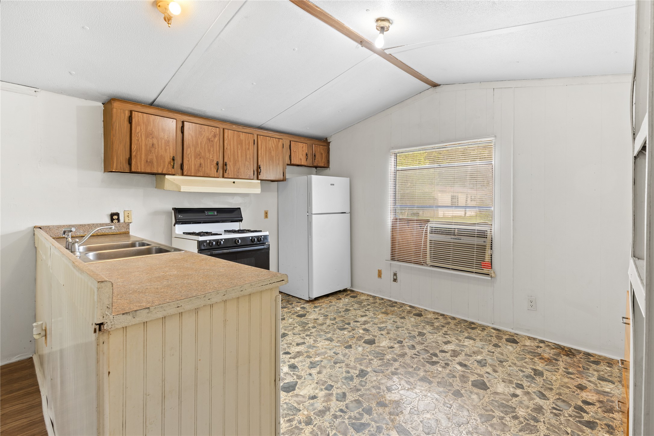370 Lakeside Drive Trinity, TX 75862 - Photo 5 of 23 a kitchen with stainless steel appliances granite countertop a refrigerator a stove a sink dishwasher and white cabinets with wooden floor