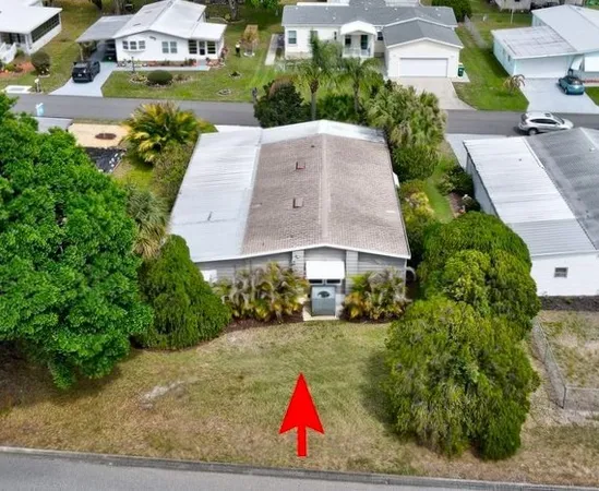 an aerial view of residential houses with outdoor space and trees