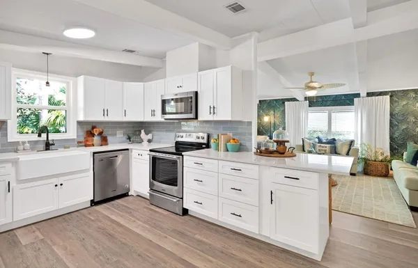 a kitchen with white cabinets and white appliances