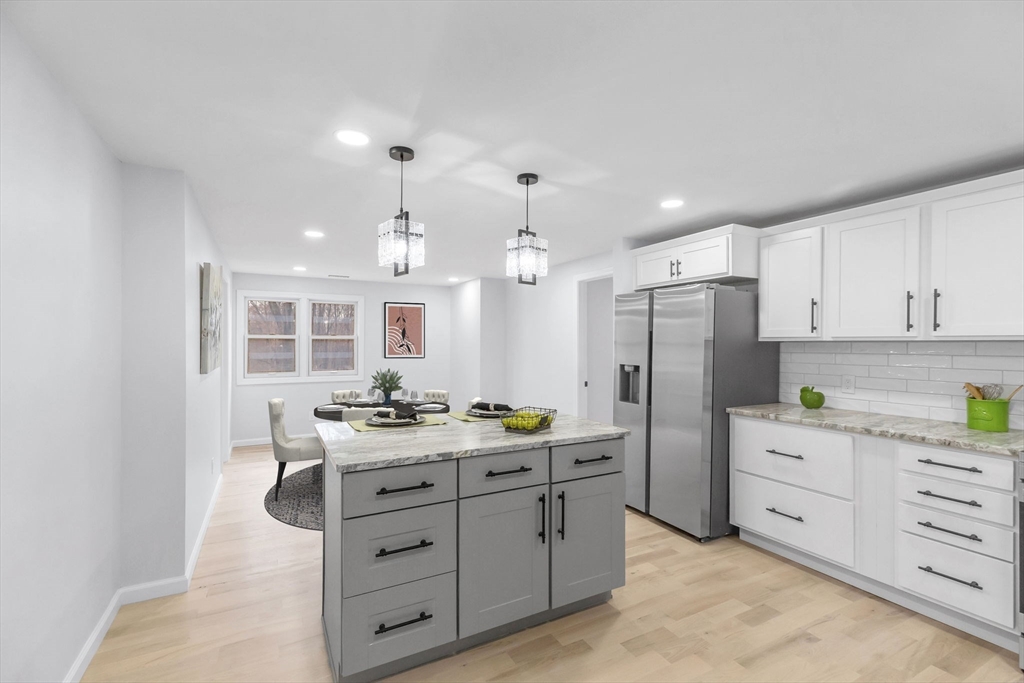 143 James Street Ludlow, MA 01056 - Photo 12 of 41 a kitchen with a refrigerator a sink dishwasher a stove and white cabinets with wooden floor