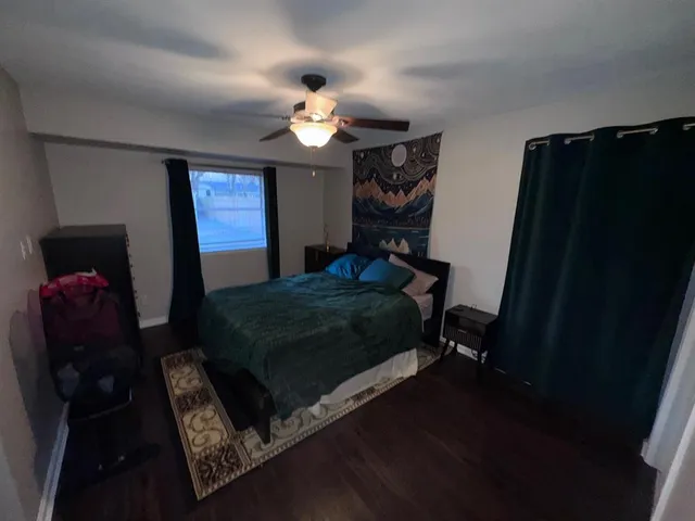 a bedroom with a bed dresser and a mirror