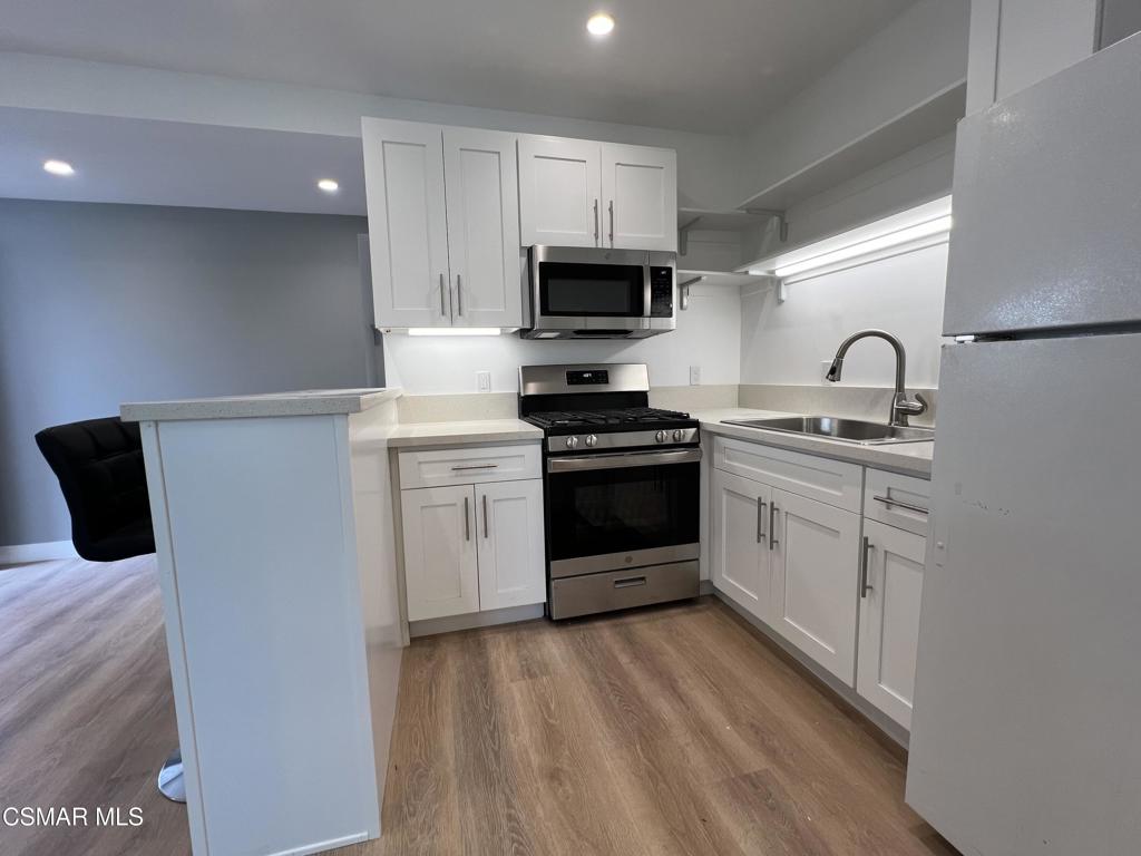 1666 1/2 Stoddard Avenue Thousand Oaks, CA 91360 - Photo 1 of 17 a kitchen with white cabinets stainless steel appliances and sink