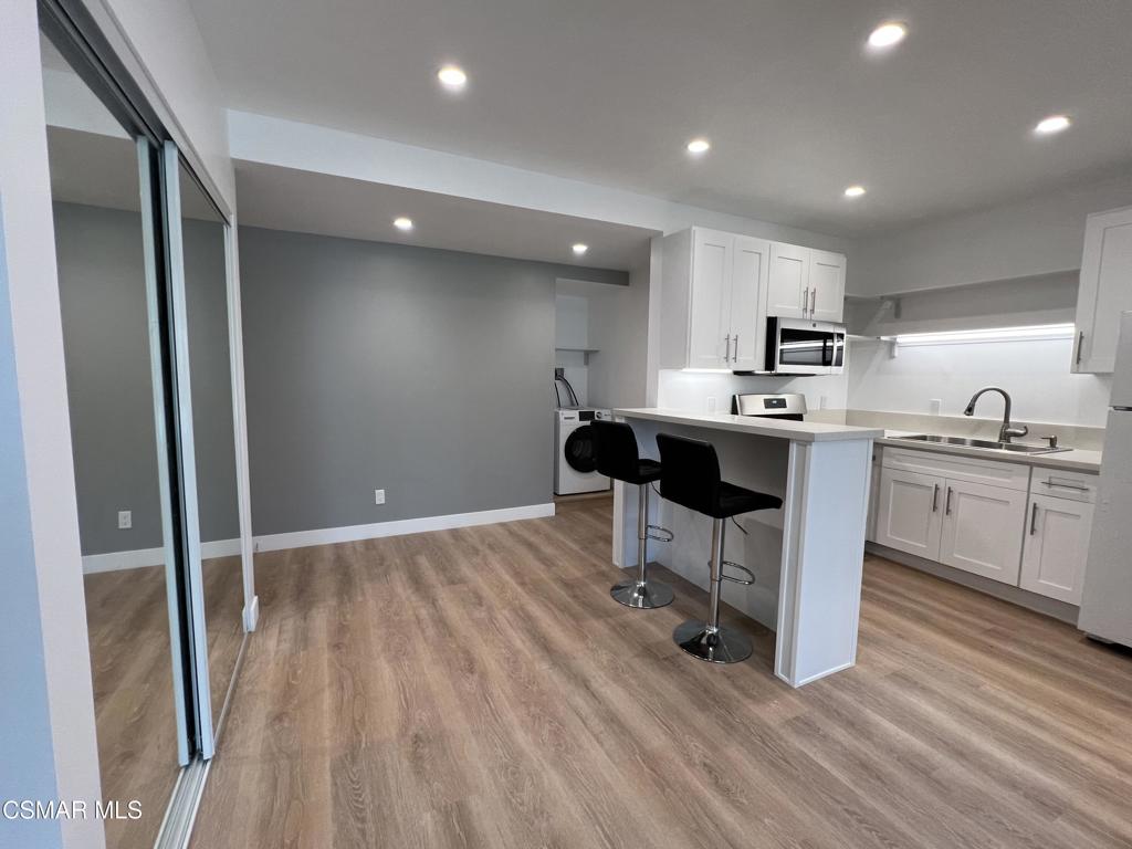 1666 1/2 Stoddard Avenue Thousand Oaks, CA 91360 - Photo 11 of 17 a kitchen with kitchen island a sink stainless steel appliances and cabinets
