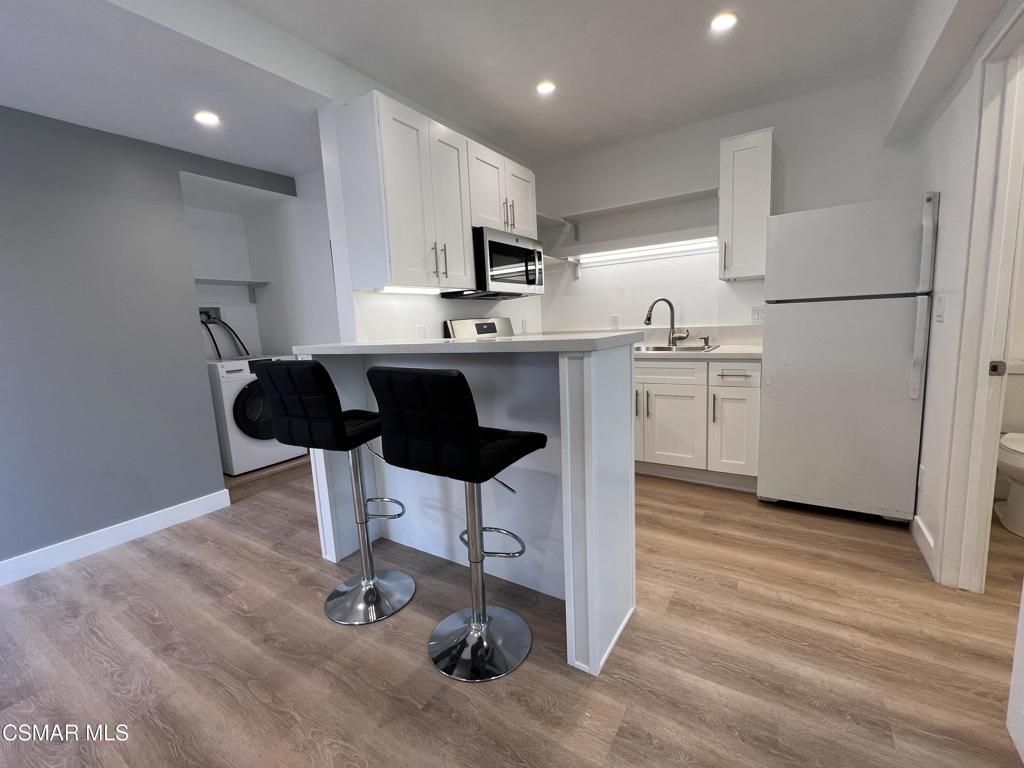 1666 1/2 Stoddard Avenue Thousand Oaks, CA 91360 - Photo 2 of 17 a kitchen with stainless steel appliances granite countertop a refrigerator a stove a sink dishwasher and a refrigerator with wooden floor