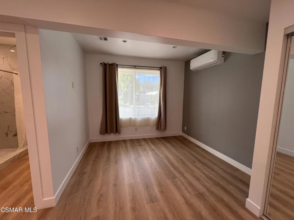 1666 1/2 Stoddard Avenue Thousand Oaks, CA 91360 - Photo 9 of 17 a view of an empty room with wooden floor and a window
