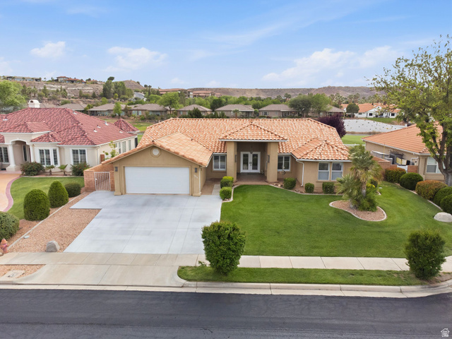 1985 West Rivers Edge Lane St. George, UT 84770 - Photo 2 of 42 Mediterranean / spanish-style home with a residential view, stucco siding, a tiled roof, driveway, and a front yard