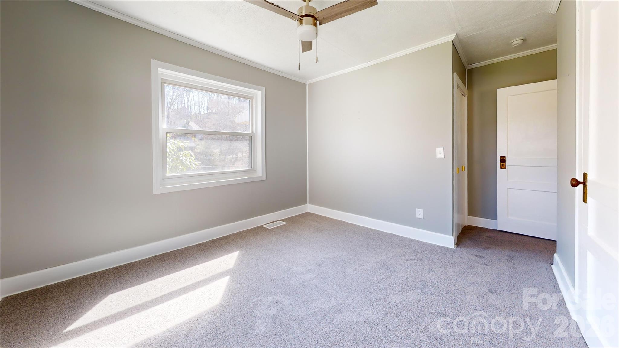 882 Poison Cove Road Clyde, NC 28721 - Photo 18 of 22 an empty room with windows and ceiling fan
