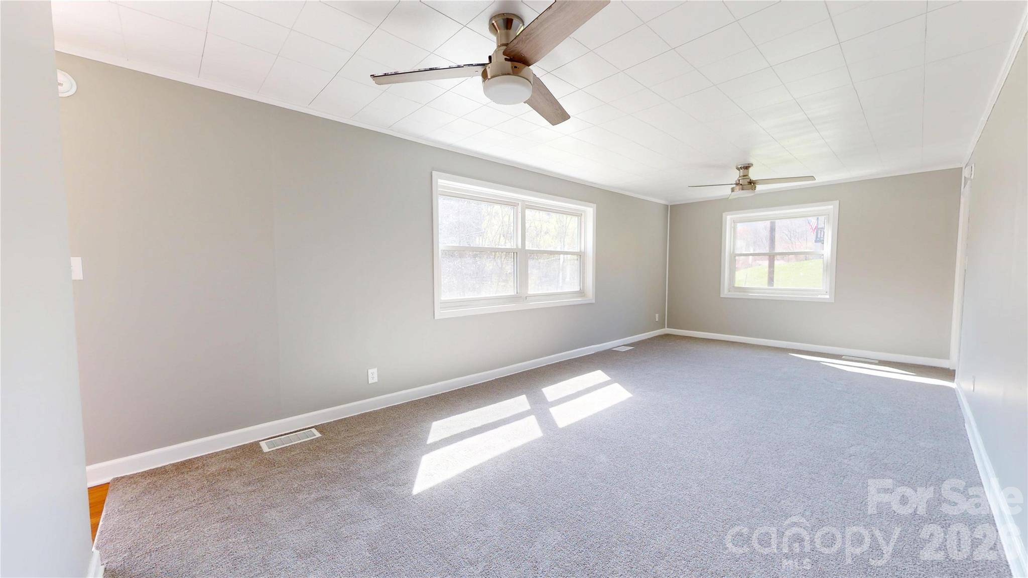 882 Poison Cove Road Clyde, NC 28721 - Photo 7 of 22 an empty room with windows and fan