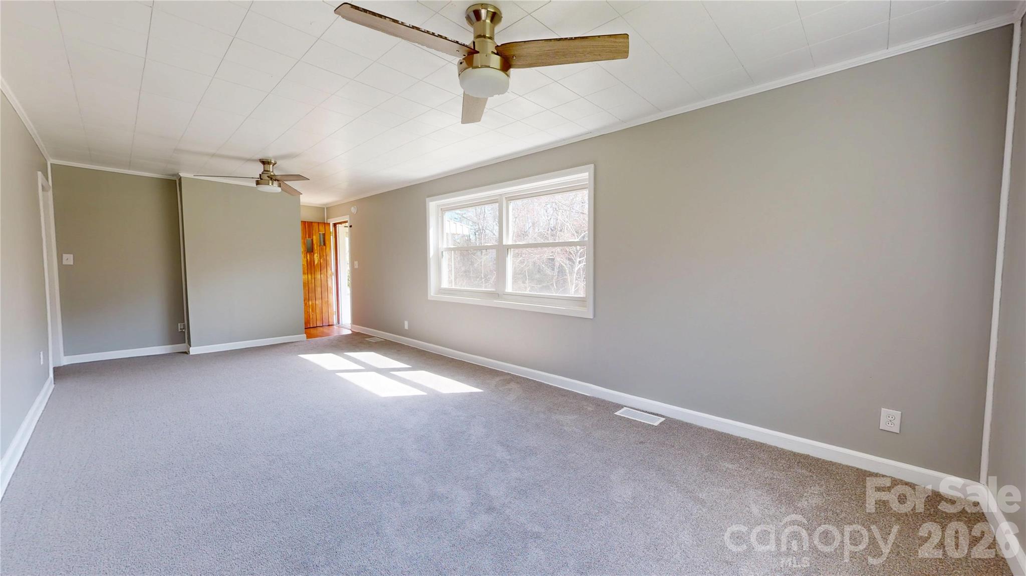882 Poison Cove Road Clyde, NC 28721 - Photo 8 of 22 an empty room with windows and fan