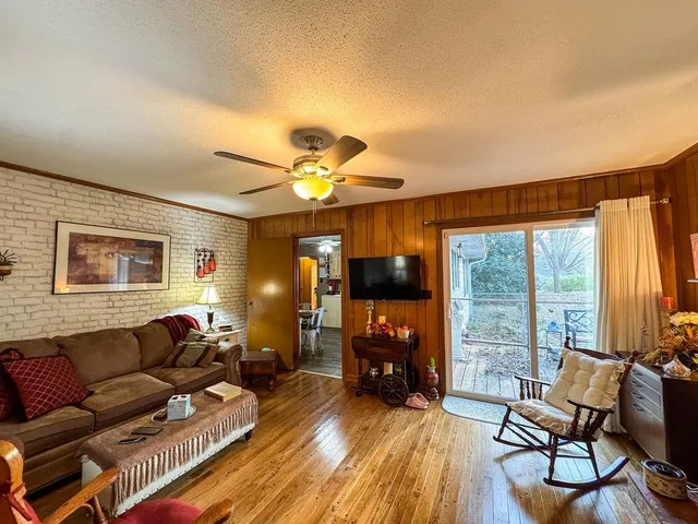a living room with furniture and a flat screen tv with wooden floor