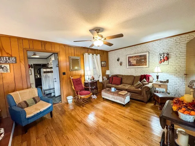 a living room with furniture a ceiling fan and a window