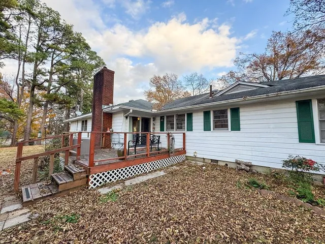 a front view of a house with yard tree and wooden fence