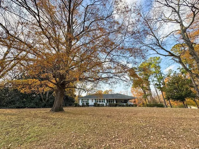 a front view of house with yard and trees