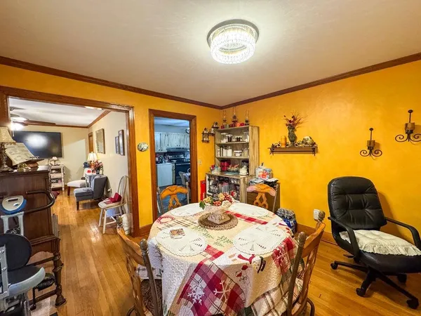 a bedroom with a bed and dresser with wooden floor