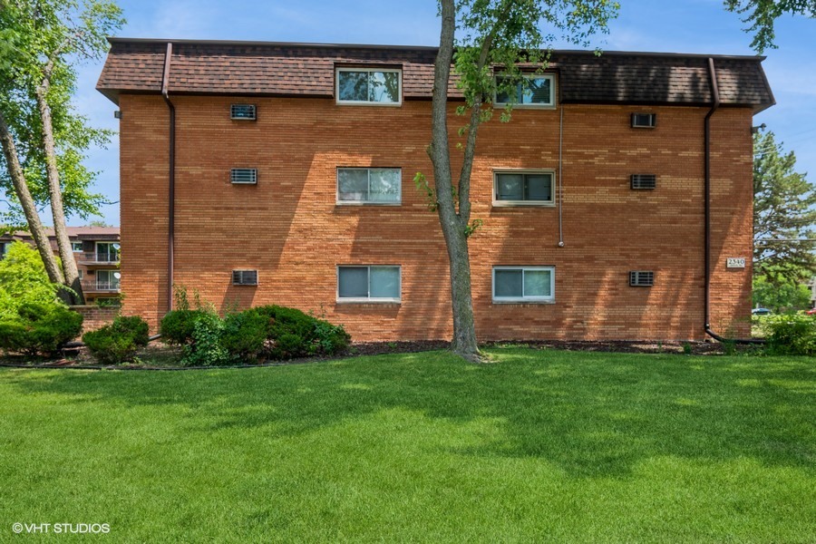 2340 186th Street, Unit 28 Lansing, IL 60438 - Photo 2 of 14 a brick building with a yard