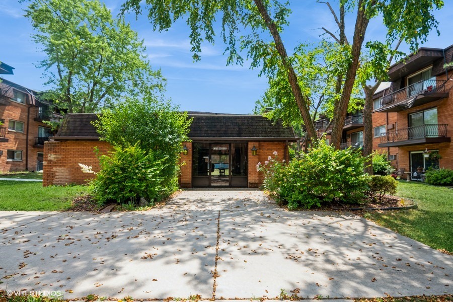 2340 186th Street, Unit 28 Lansing, IL 60438 - Photo 3 of 14 a front view of a house with a yard and tree s