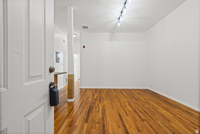 70 North Main Street, Unit 213 Bountiful, UT 84010 - Photo 4 of 15 Spacious room featuring rich wood-finish flooring, crisp white walls, and contemporary track lighting