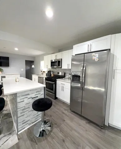 a kitchen with kitchen island a counter top space appliances and cabinets
